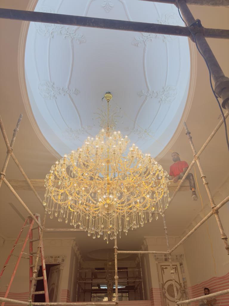Grand ornate crystal chandelier under installation